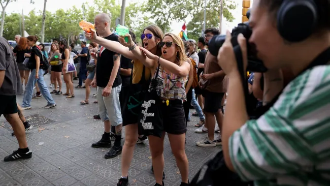 Why are protesters squirting water at tourists in Barcelona?